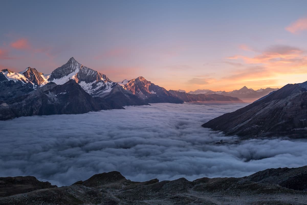 Mountain peaks rising above a sea of clouds at sunrise